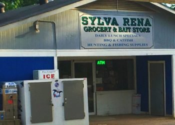 Exterior of building with bright blue walls and a white sign that says "Sylva Rena Grocery and Bait Store" in green letters.