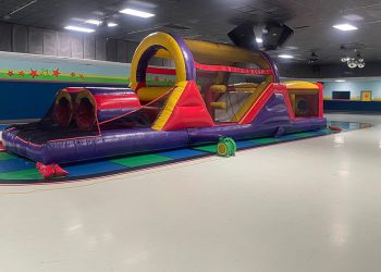 inflatable multicolor moon bounce inside of a building