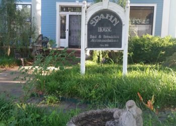 Exterior of Spahn House, with blue and white accents and a small garden with a bird bath.